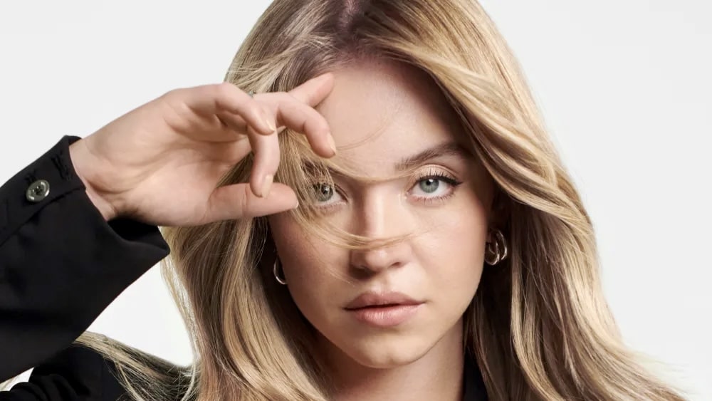 Sydney Sweeney with blonde hair in Kérastase beauty campaign photo.